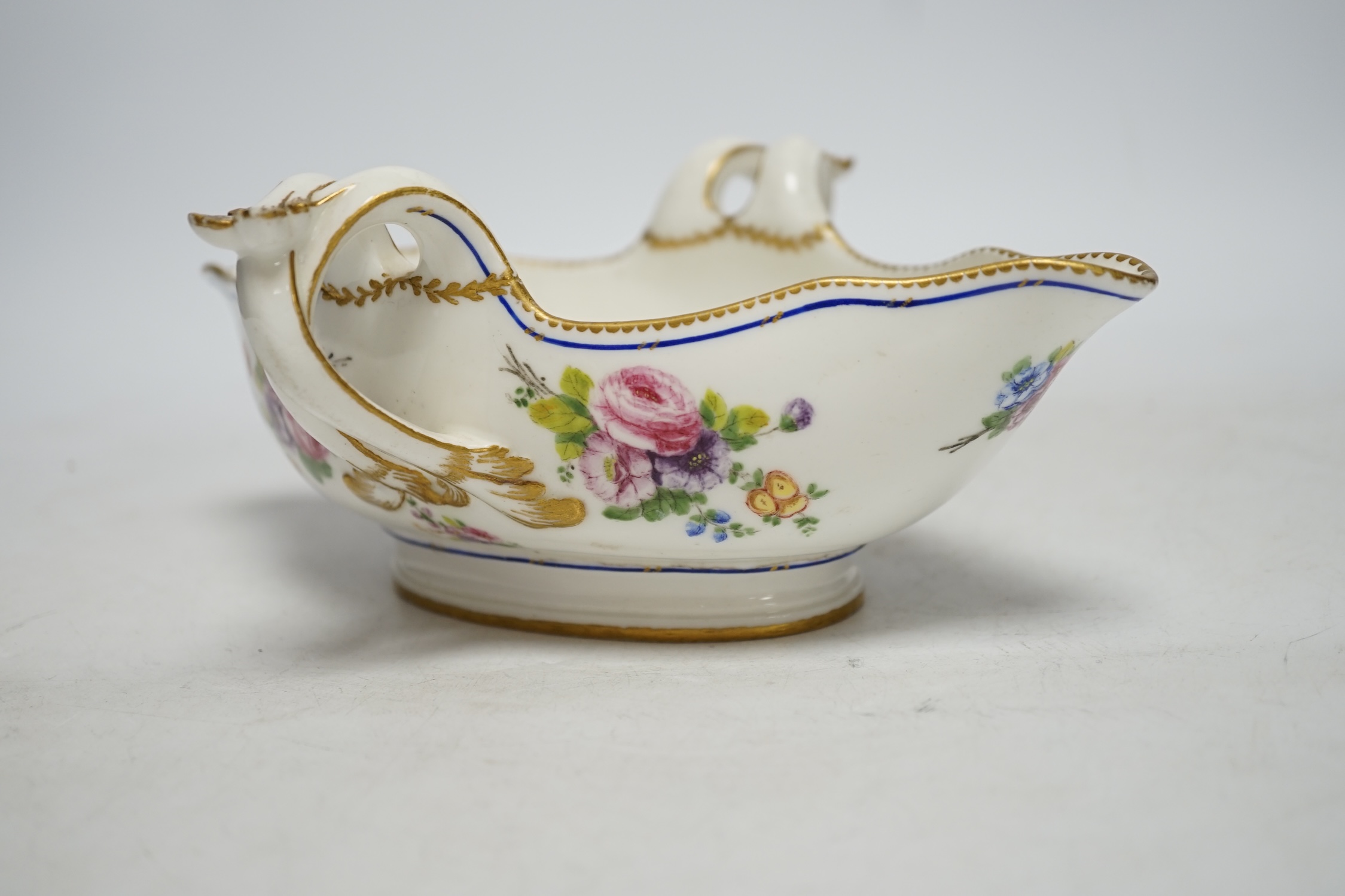 An 18th century Sevres sauceboat, probably later enamelled with flowers, 23.5cm wide